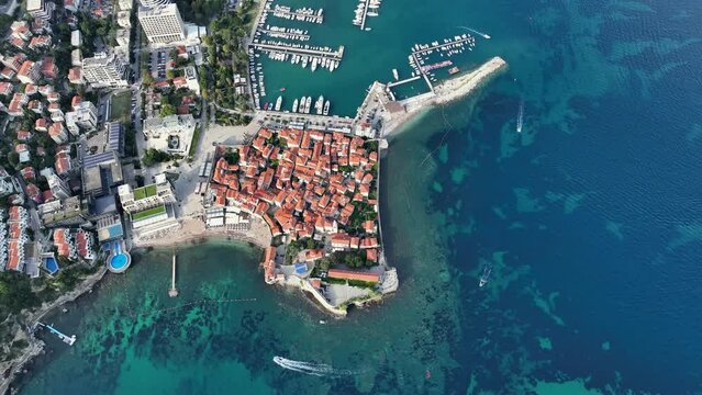Aerial Drone Shot of Budva. Historical part of the city washed by th sea. Buildings with red roofs. Montenegro.