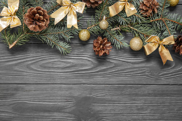 Beautiful Christmas composition with fir branches, cones and decorations on dark wooden background
