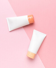 Two tubes of cream on a two-tone background. The concept of body care.