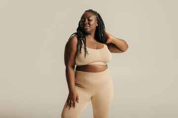 Attractive African curvy woman in underwear radiating self-love on studio background