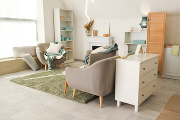 Interior of living room with armchairs and fireplace