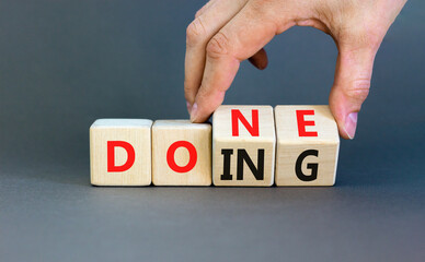 Doing and done symbol. Concept words Doing Done on wooden block. Beautiful grey table grey...