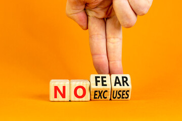 No fear and excuses symbol. Concept words No fear No excuses on wooden block. Beautiful orange table orange background. Businessman hand. Business motivational no fear and excuses concept. Copy space.