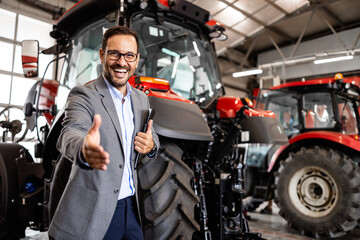 Fototapeta na wymiar handsome caucasian man in business suit selling tractors and farming equipment.