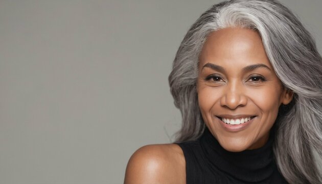 Smooth healthy skin and long gray hair on a beautiful black mature woman smiling happily in beauty and cosmetics skincare advertising concept