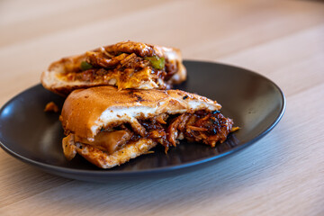 Italian pieces of shawarma full of peppers and BBQ sauces with chicken on black plate on wooden table table with dips
