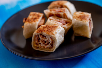 Shawarma pieces on black plate with blue background isolation  and copy space