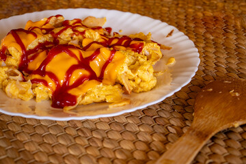 Egg and cheese with ketchup topping beside it some avocado