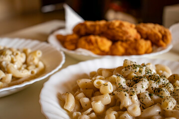 macaroni served with chicken nugget on table topped with spices and herbs with cream sauces and called bechamel