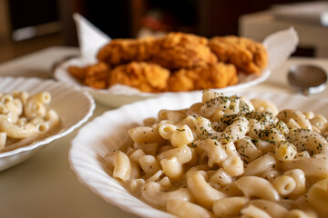macaroni served with chicken nugget on table topped with spices and herbs with cream sauces and called bechamel