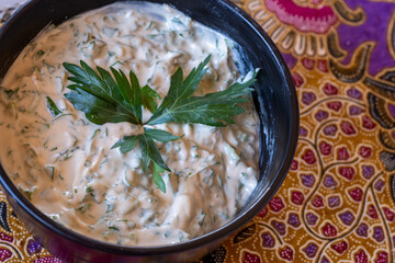 Fototapeta premium parsley with tahini mixed and served in black plate with wooden background