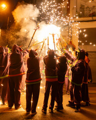 Diables con fuegos artificiales en la calle en fiestas mayores