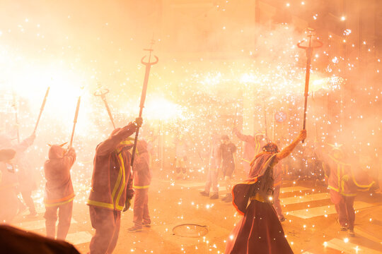 Diables con fuegos artificiales en la calle en fiestas mayores