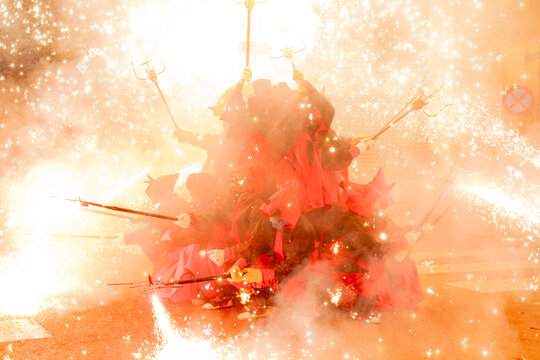 Diables con fuegos artificiales en la calle en fiestas mayores