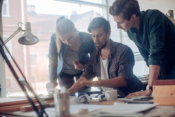 Group of young male and female designers working on a project in the office