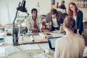 Young and diverse group of architects working on a project together in a startup company office