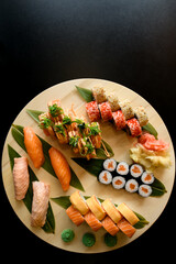 Fototapeta na wymiar Assorted sushi rolls on a round wooden board