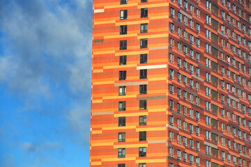 Fototapeta premium glazed facade of a high-rise building against a blue sky with clouds