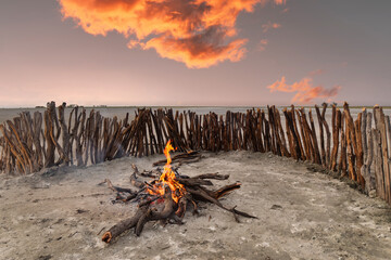 Botswana , in Kalahari desert bonfire surrounded by a wooden fence to protect from the wind in the kraal enclosure for cattle or goats - obrazy, fototapety, plakaty