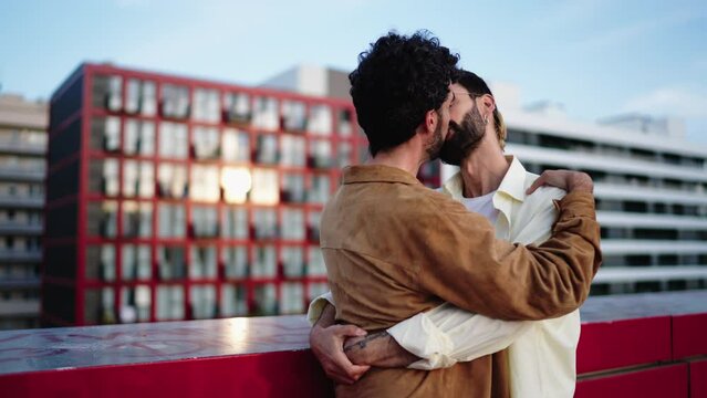 Harmonious Love, Two gay men gaze at each other with undeniable tenderness, enjoying LGBT relationship and embracing love. Romantic and happy homosexual couple kissing outdoors during valentine dating