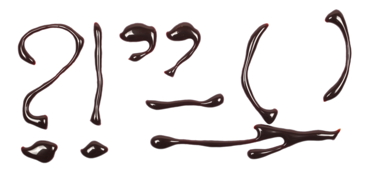 Chocolate topping, melted in shapes punctuation marks isolated on white, top view