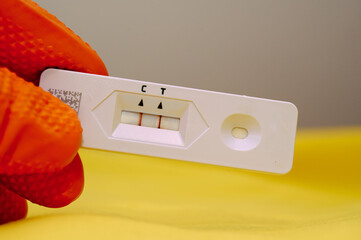 Glove hand holding Positive Covid Test