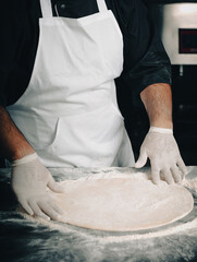 hands knead the dough for pizza making