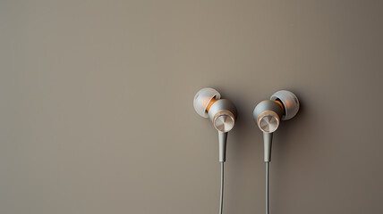 Silver earphones on neutral background, with copy space. Modern music technology.
