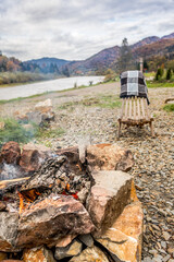 A view of the fireplace, mountains and lake. Journey to the Ukrainian Carpathians. Tongues of flame. Stones for barbecue. Warming up by the fire. Romance of the mountains. Fall nature.