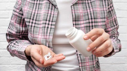 A woman holds pills in her hand. Flu medicine, pain reliever, vitamins. Concept of medicine.