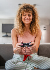 young woman play console video games hold joystick at home happy smile