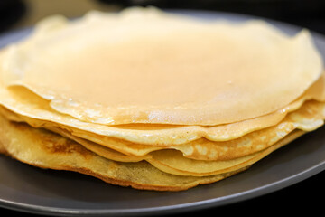 Making bliny at home. Closeup of traditional tasty thin pancakes. Photo with selective focus and...