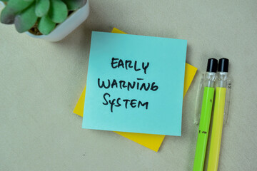 Concept of Early Warning System write on sticky notes isolated on Wooden Table.