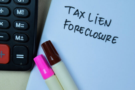 Concept of Tax Lien Foreclosure write on book isolated on Wooden Table.