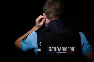 Un gendarme qui écoute un message à l'oreillette