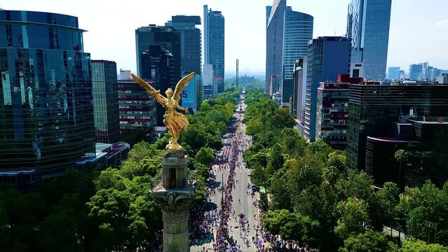 Aerial view from Mexico angel de la independencia monument in a festival dia de muertos parade, alebrijes art in reforma street