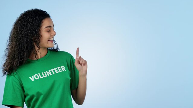Volunteer, pointing and face of woman in studio for charity, donation and community service decision. Portrait of person with hand gesture for volunteering, NGO choice or mockup on blue background