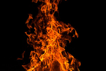 Orange fire flame on dark black background, abstract texture