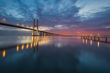 Photo sur Plexiglas Pont Vasco da Gama Vasco da Gama bridge and pier over tagus river in Lisbon at dawn