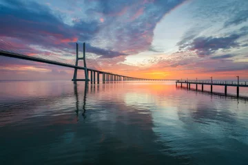 Photo sur Plexiglas Pont Vasco da Gama Vasco da Gama bridge and pier over tagus river in Lisbon at sunrise