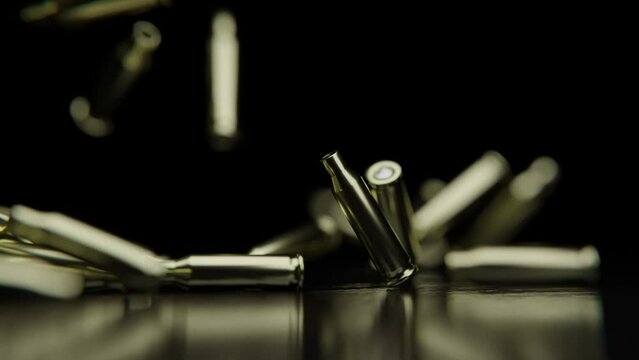 Close up shot of Golden Bullets falling down on a reflective surface