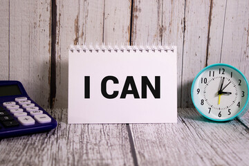 Yes you can text. a wooden table and a notebook that says Yes you can.