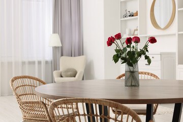 Chairs and table with vase of red rose flowers in dining room. Stylish interior