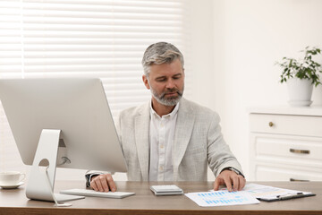 Fototapeta premium Professional accountant working at wooden desk in office