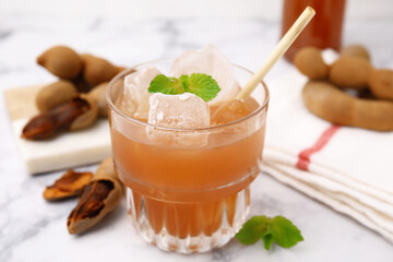 Freshly made tamarind juice with mint on white marble table, closeup