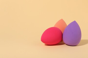 Many different makeup sponges on beige background, space for text