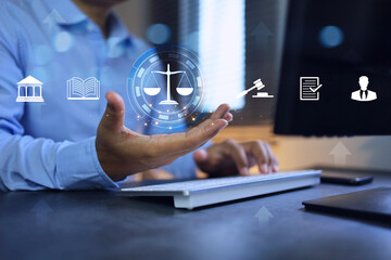 Law regulation concept. Businessman or lawyer holding balance of justice to legal study on computer application. - obrazy, fototapety, plakaty