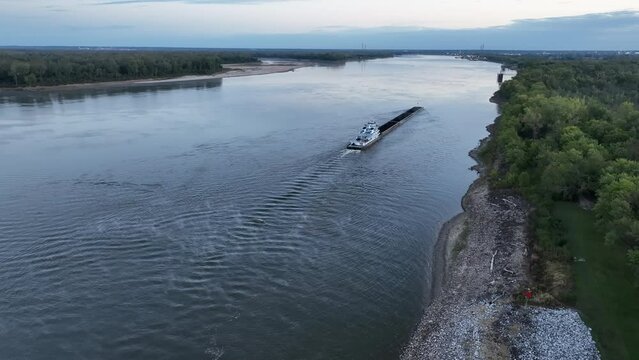 towboat with barges on the Mississippi River at confluence with the Missouri River below Alton, IL