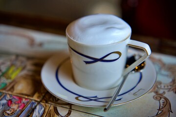 The Cup of cappuccino on a wooden table in a cafe. Beautiful foam, white ceramic cup, copy space.
