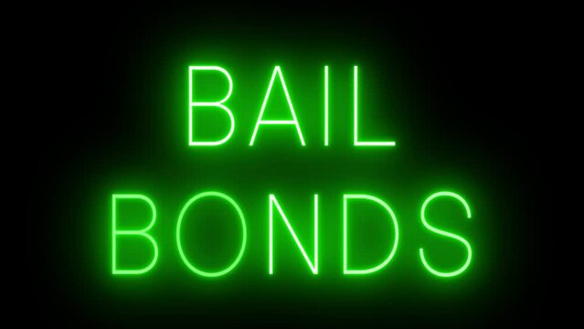Flickering green retro style neon sign glowing against a black background for BAIL BONDS